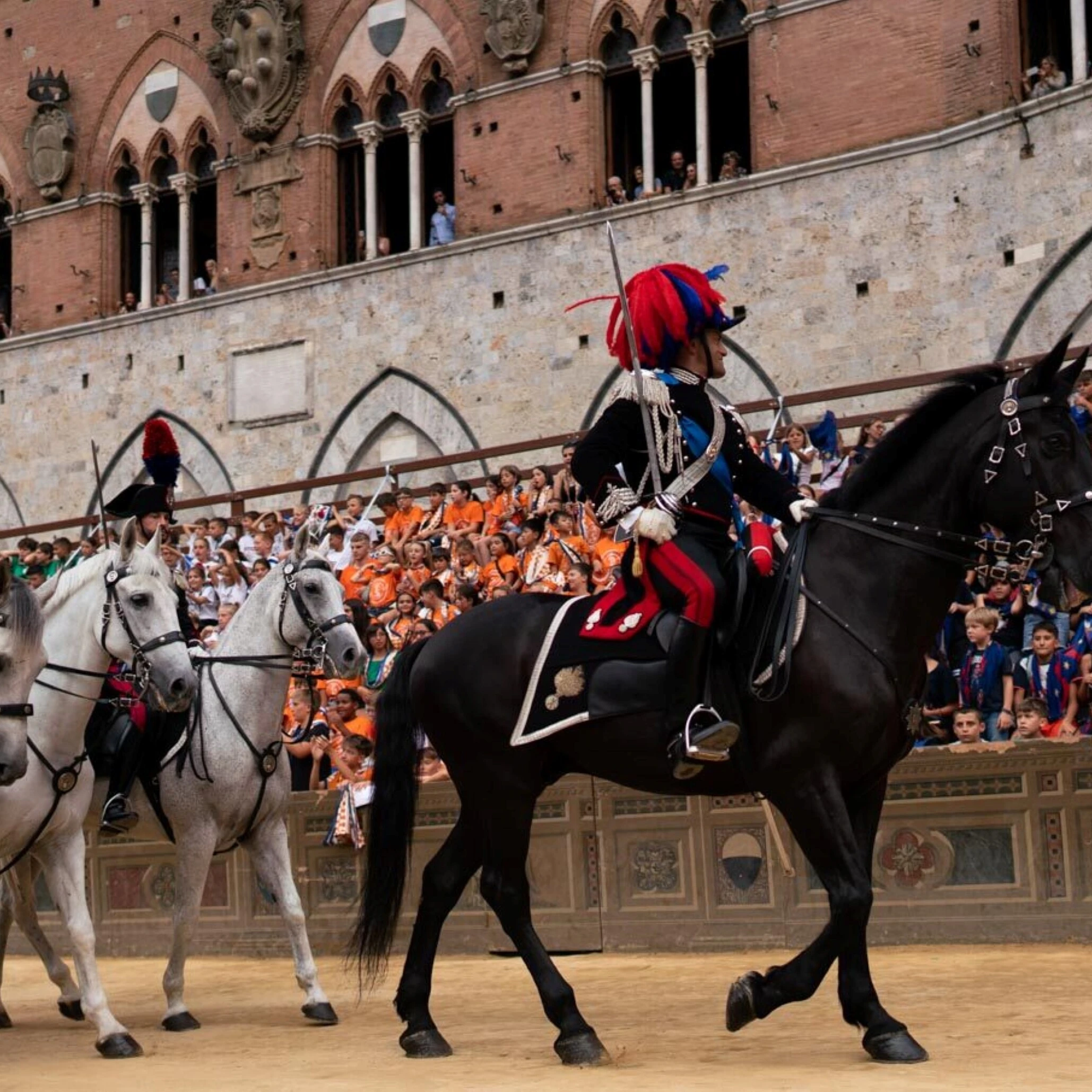 La Dolce Vita cavaliers en tenue cérémonielle défilant sur la Piazza del Campo lors du Palio de Sienne